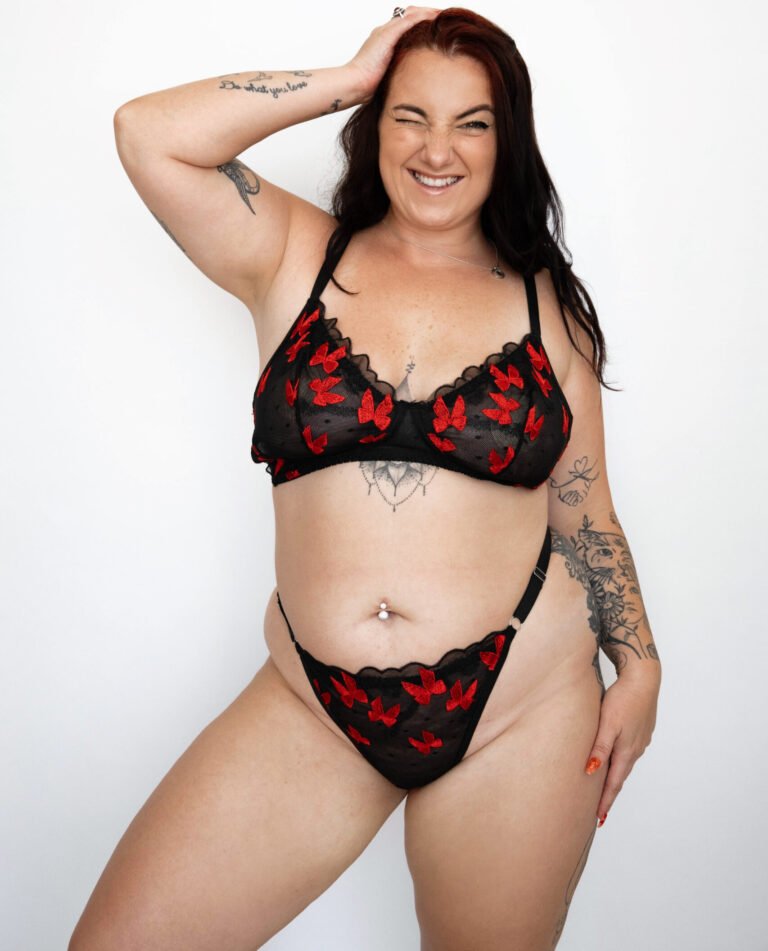 סט תחרה פרחוני למידות גדולות בצבע אדום ודוגמת פרפרים על רקע שחור מהמותג להלבשה תחתונה של דנה טנא. החזיה רכה כמו גוזיה, היא ללא ריפודים או ברזלים והתחתון בגזרת חוטיני סקסי, תמונה קדמית